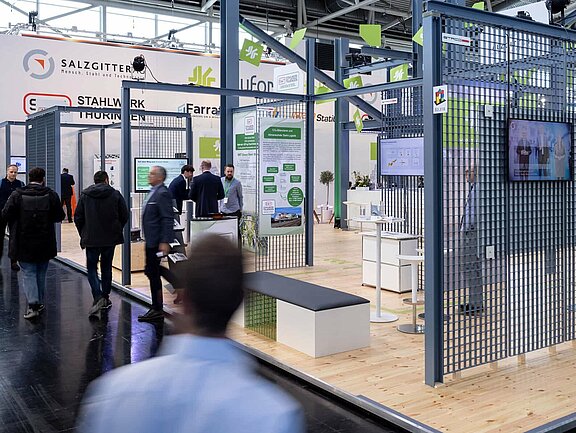 Messestand von Bauforumstahl, umgesetzt von Holtmann+, in einer Messehalle in München 2023 auf der Messe BAU.